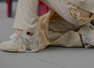 A woman wearing all beige, including some women's only Jordan 4 off-white