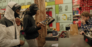 A group of 3 individuals looking at sneakers that were sold for 99p